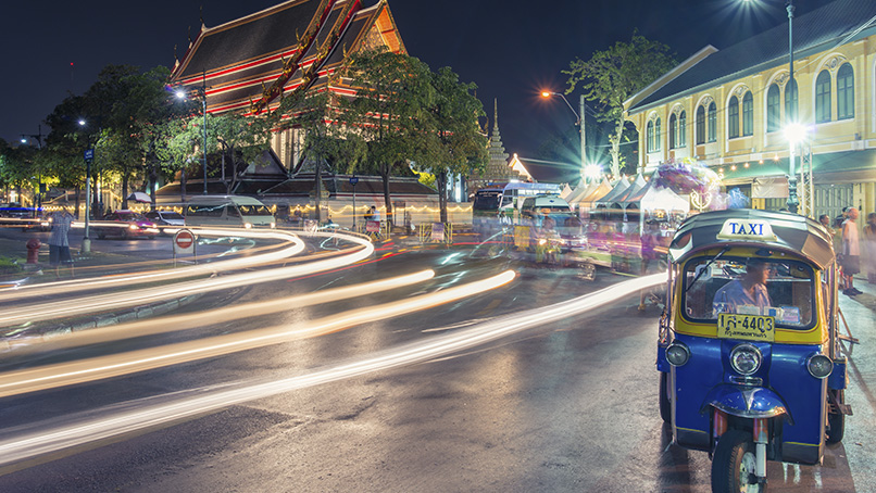 Tuk-tuk and light trails on a Bangkok street at night